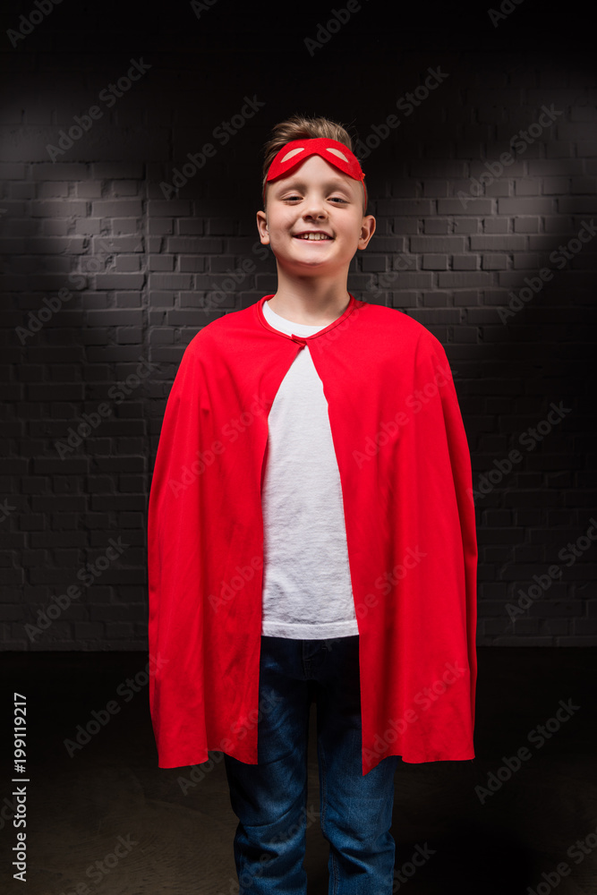 smiling boy in superhero costume and mask