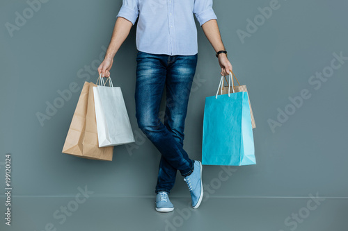 Shopping bags. Close up of colorful shopping bags being held by a nice handsome young man