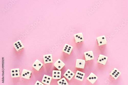 Gaming dice with copy space on pink background. Concept for games, game board, presentation, banners or web. Top view. Close-up.