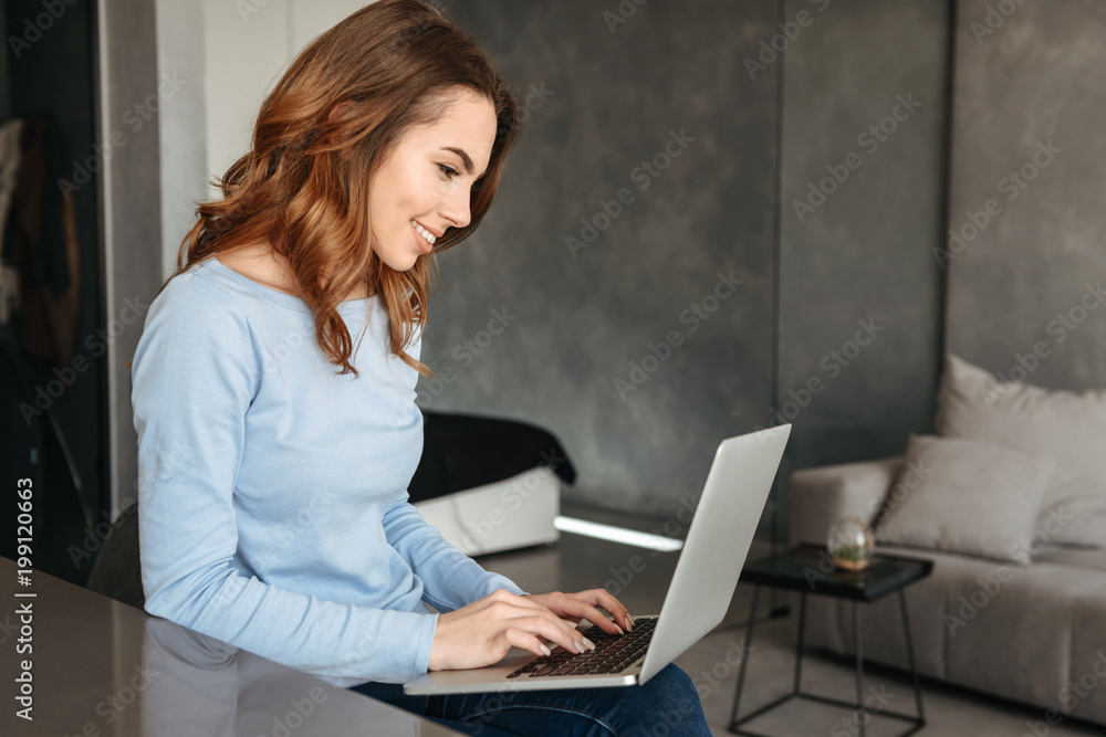 Portrait of a smiling young woman using laptop computer Portrait of a smiling young woman using laptop computer