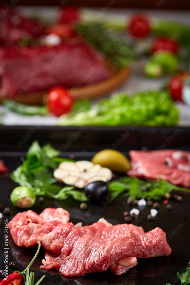 Still life of raw beef meat with vegetables on wooden plate over white background, top view, selective focus Still life of raw beef meat with vegetables on wooden plate over white background, top view, selective focus
