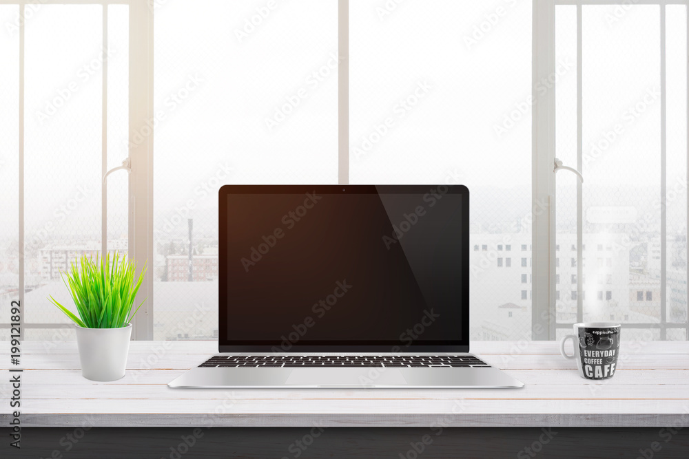 Modern laptop on white wooden desk for mockup, web site design promotion. Plant and cup of coffee beside. Window and sun light in background. Modern laptop on white wooden desk for mockup, web site design promotion. Plant and cup of coffee beside. Window and sun light in background.