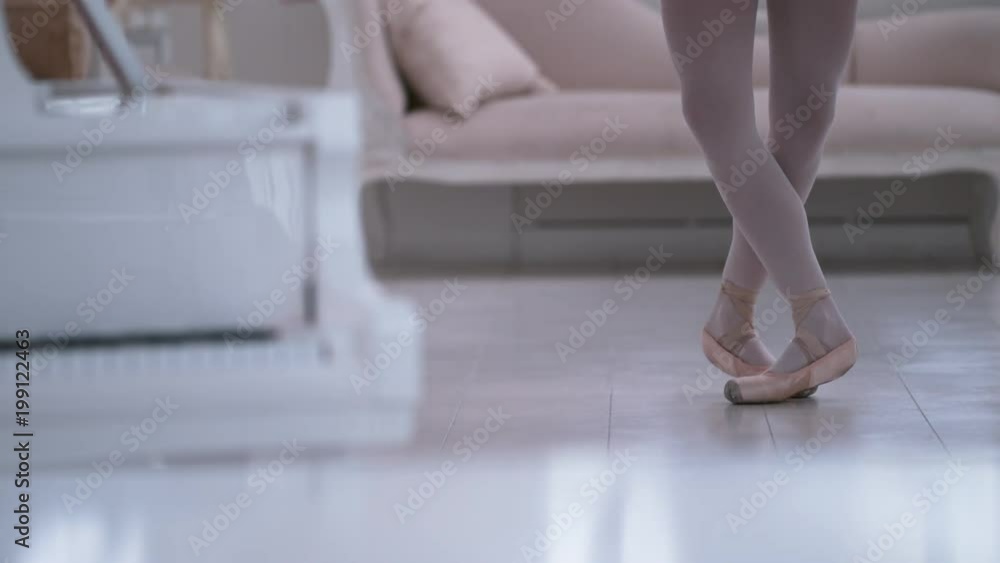 Graceful ballerina practicing ballet in white studio, slow motion Graceful ballerina practicing ballet in white studio, slow motion
