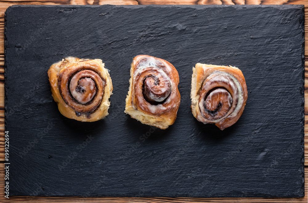 Buns with cinnamon on a black slate Buns with cinnamon on a black slate