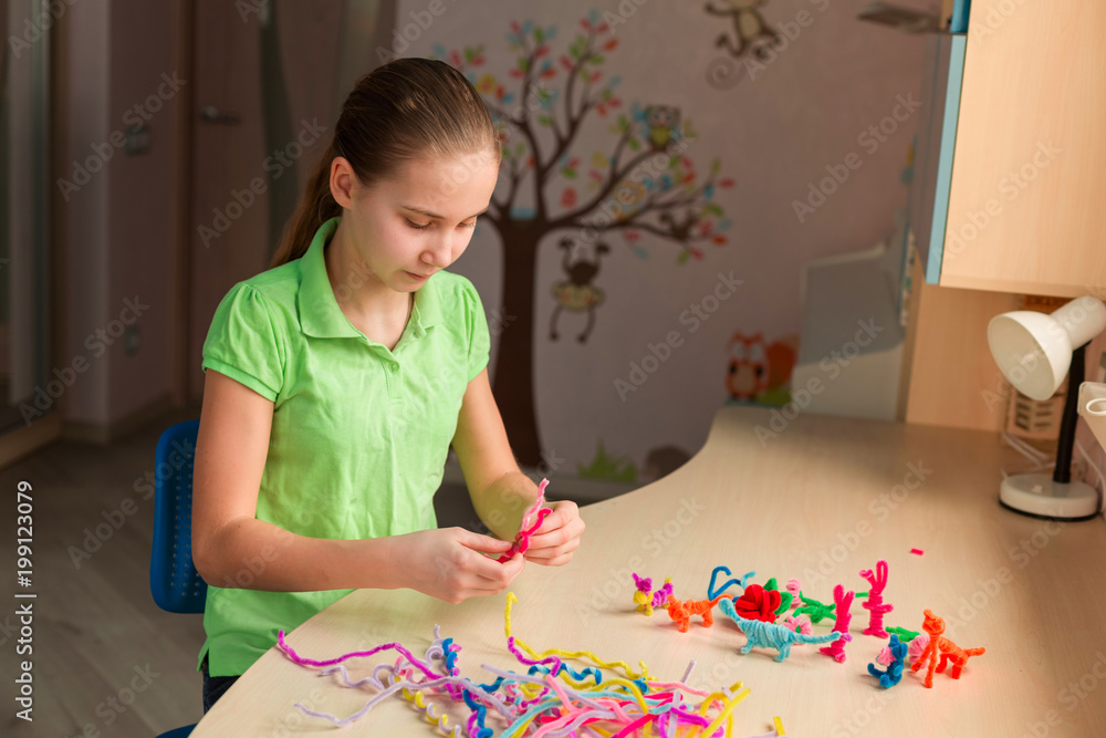 Cute little girl creating toys with chenille sticks