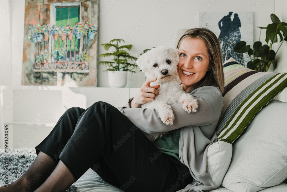 Young and beautiful sweedish blonde girl playing with her cute little french bichon dog at home. Sweet relation. Lifestyle photography Young and beautiful sweedish blonde girl playing with her cute little french bichon dog at home. Sweet relation. Lifestyle photography