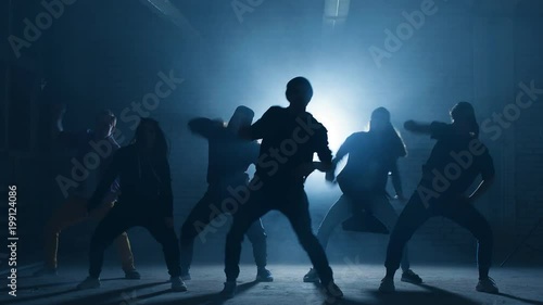 Teens taking part in dancing battle outside.