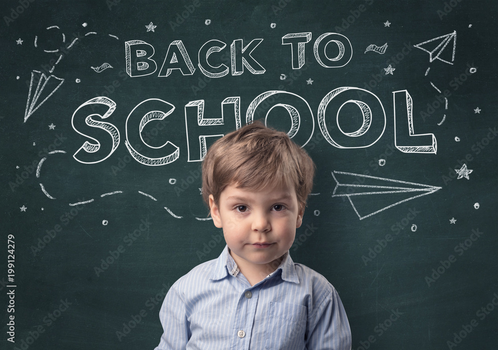 Adorable little boy with blackboard and back to school concept