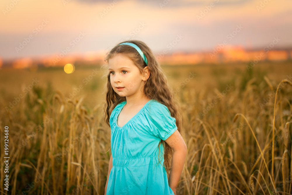 Happy girl in wheat field on warm and sunny summer evening Happy girl in wheat field on warm and sunny summer evening