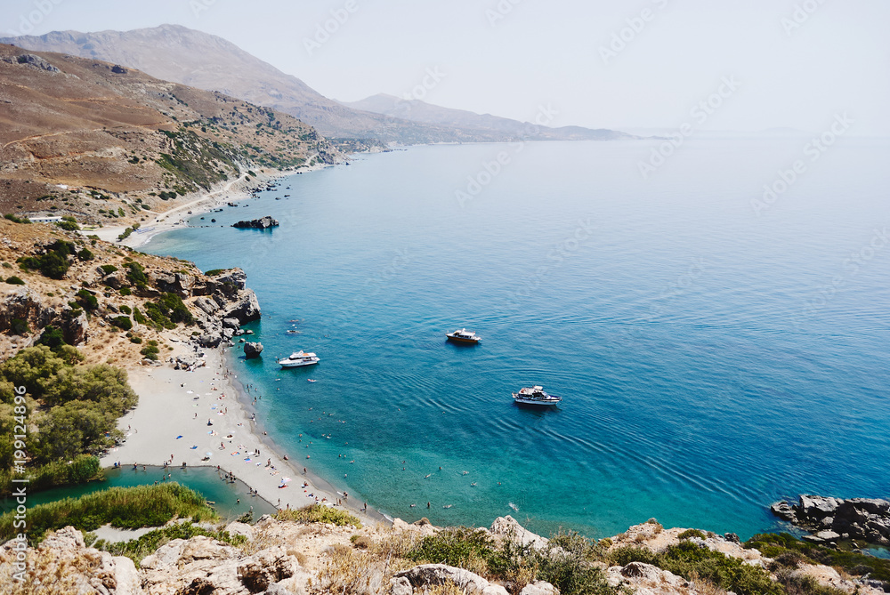 Panorama of Preveli palm beach at Libyan sea, turquoise bay with ships and mountains , Crete , Greece