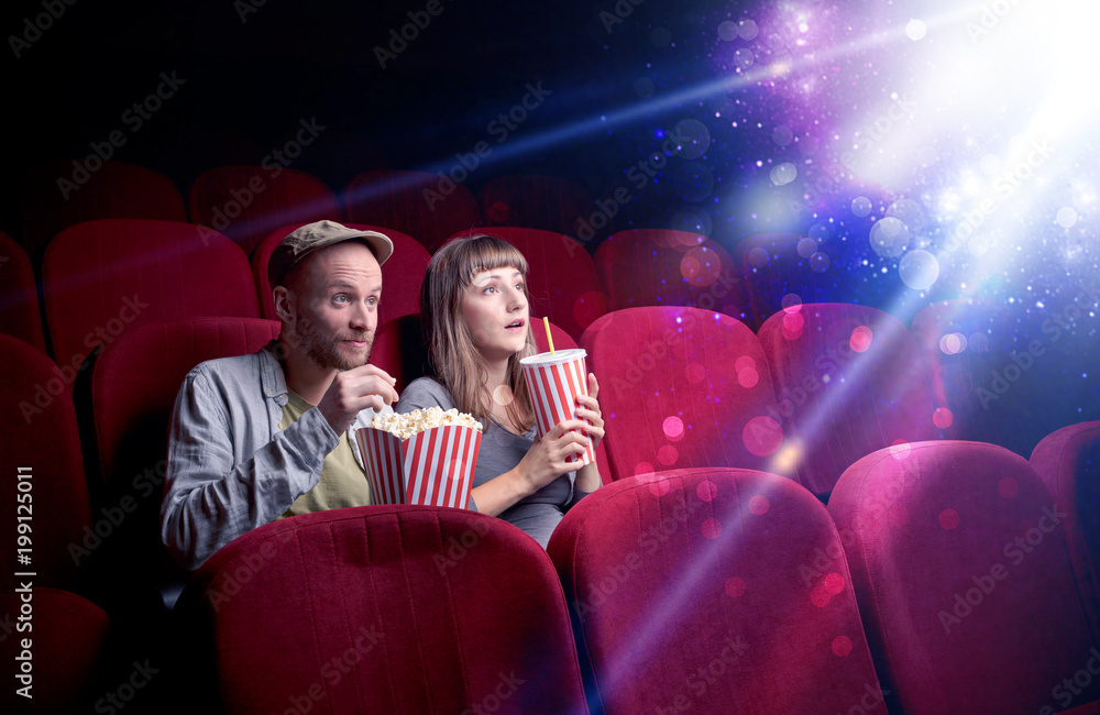 Obraz premium Romantic couple cuddling and watching the miraculous part of the film