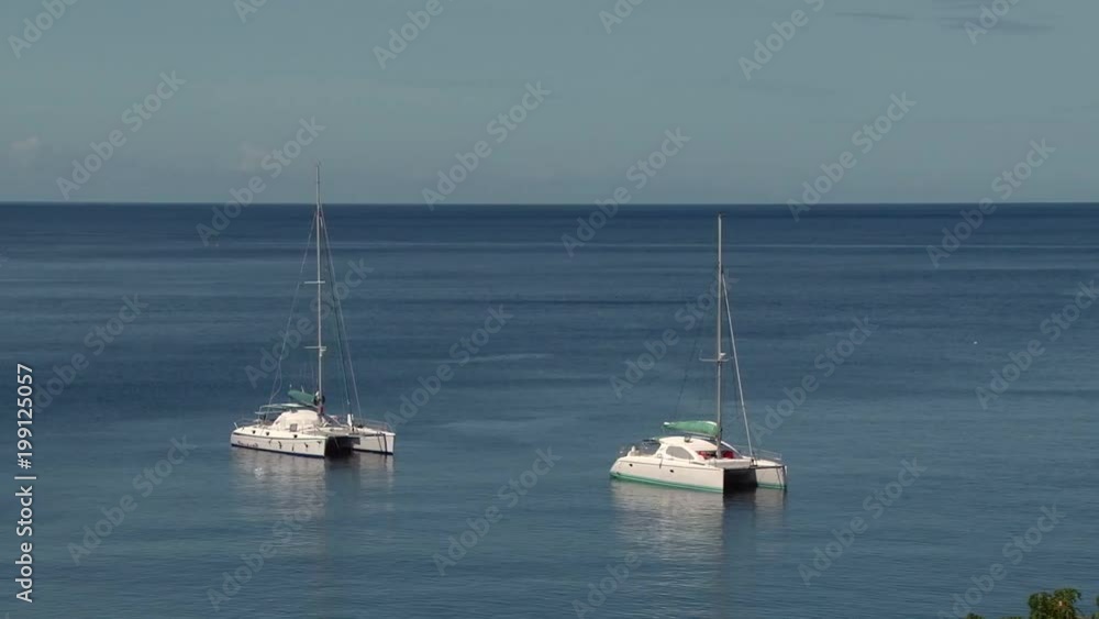 Two catamarans anchored near shore of Martinique island Two catamarans anchored near shore of Martinique island