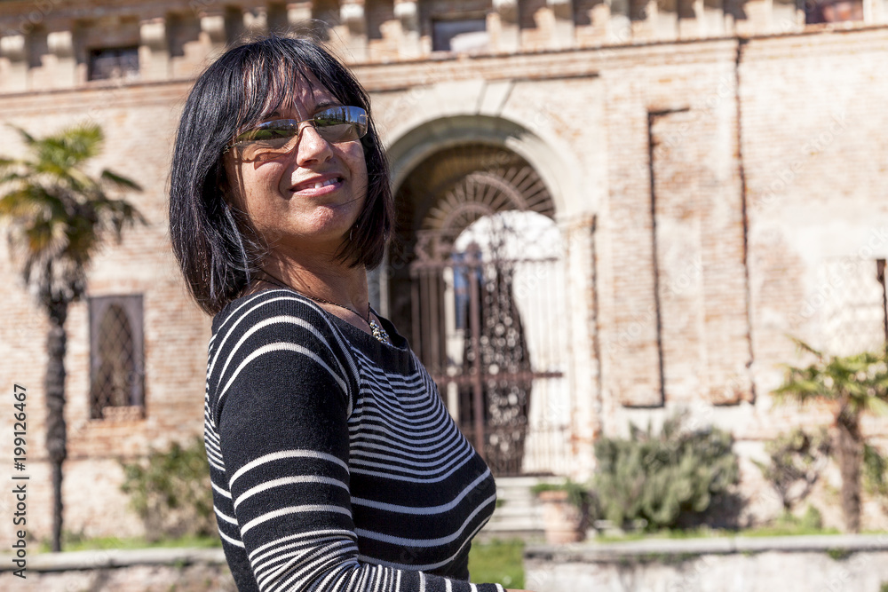 portrait of pretty woman in front of a medieval castle