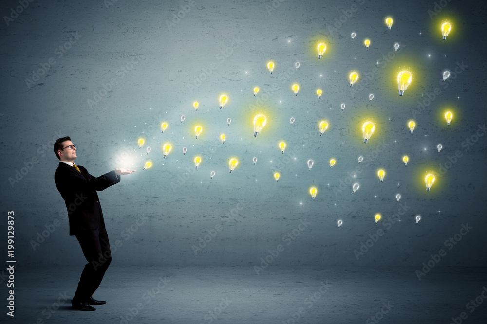 Fototapeta premium Caucasian businessman holding lightbulbs which are flying out from his hands