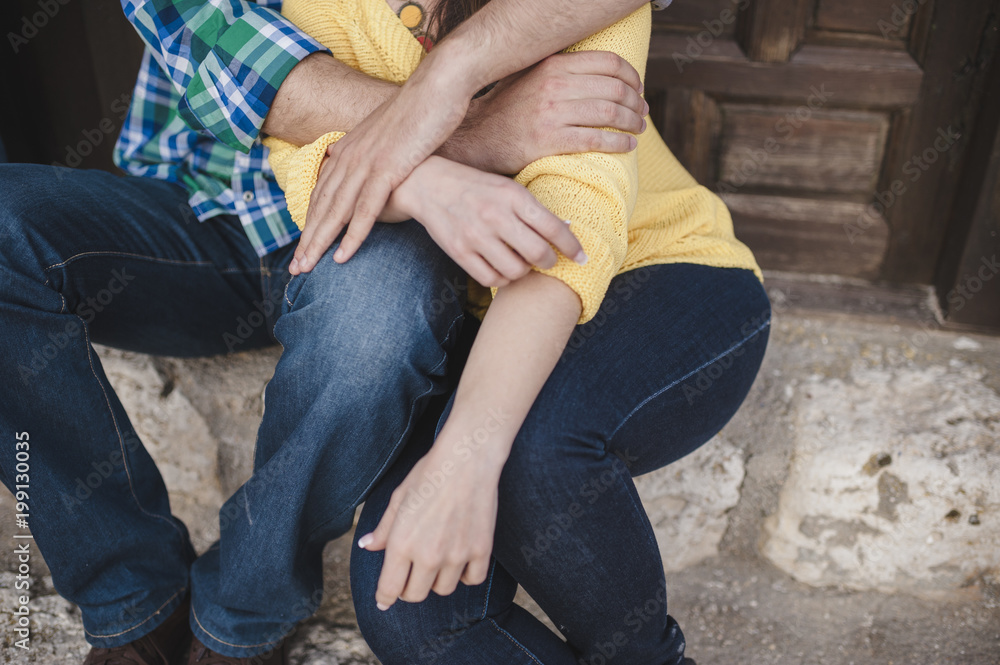 A couple in embrace seated in the street A couple in embrace seated in the street