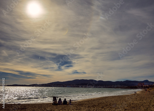 Calm beach afternoon in Palma de Mallorca. Mediterranean sea.Families and people enjoying the sun.