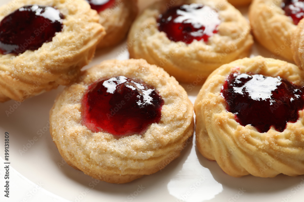 Tasty cookies with jam on plate, closeup