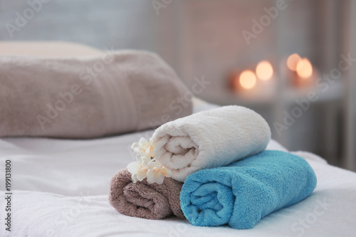 Towels and flowers on massage table in spa salon