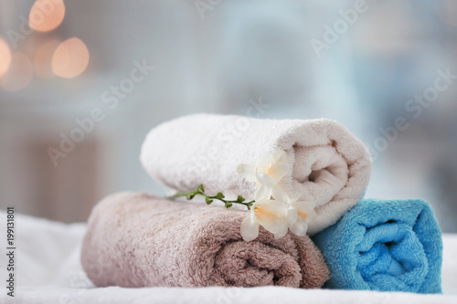 Towels and flowers on massage table in spa salon