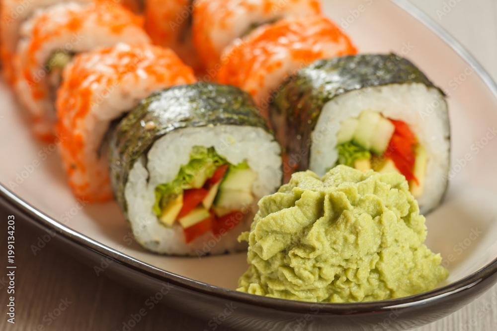 Close up wasabi and sushi rolls with vegetables, Uramaki California on the background. Japanese cuisine Close up wasabi and sushi rolls with vegetables, Uramaki California on the background. Japanese cuisine