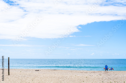 chair  umbrella and person on the beach.