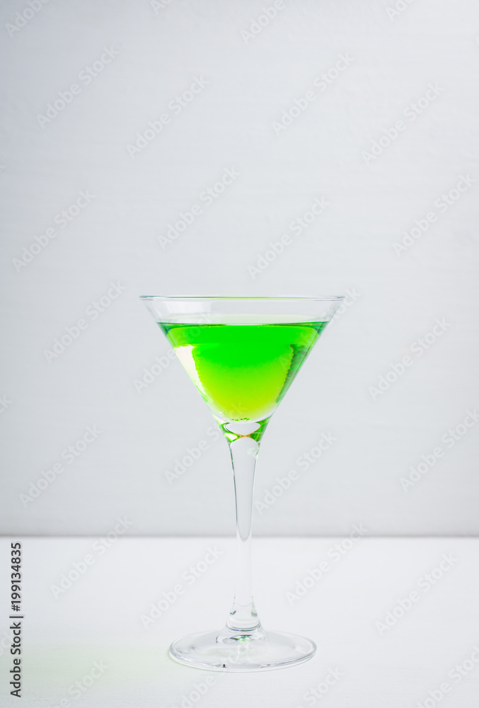 Apple martini cocktail on the white rustic background. Selective focus. Apple martini cocktail on the white rustic background. Selective focus.