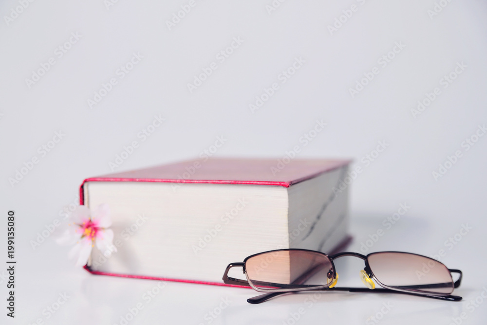 Thick red book and reading glasses Thick red book and reading glasses