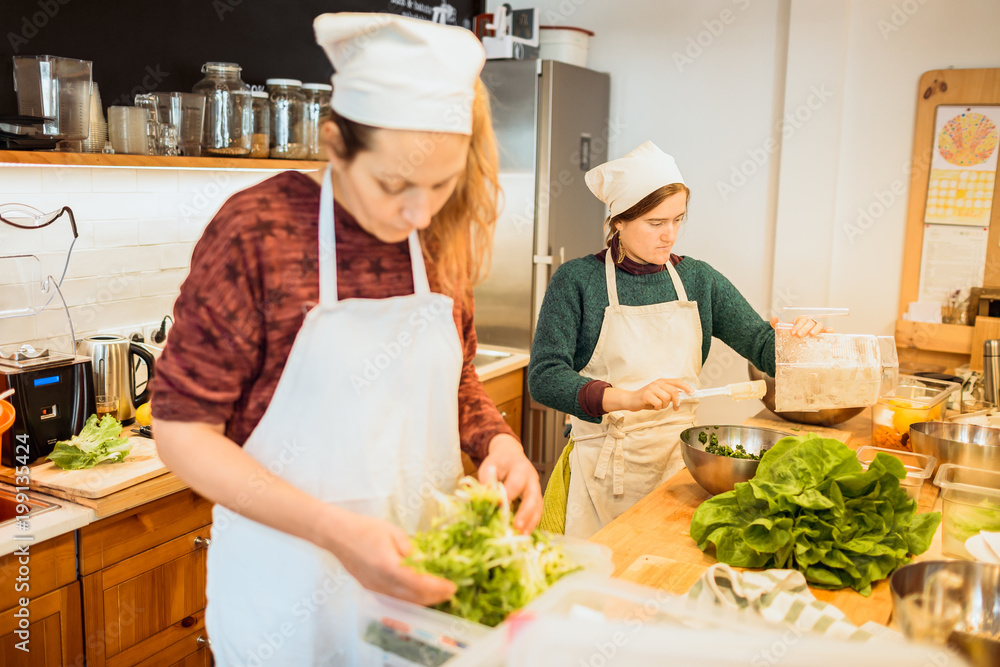Women working with lettuce on kitchen Women working with lettuce on kitchen