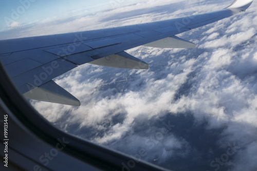 Airplane wing view from window seat above bridge