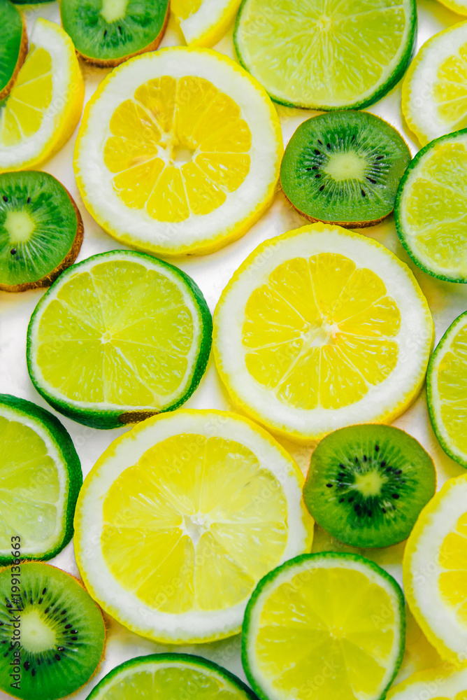 Lemon, lime and kiwi sliced slices. Fruit summer refreshing background. Isolated vertical image