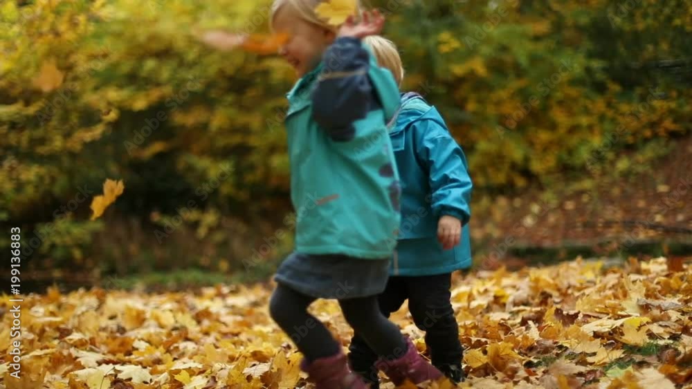 Siblings Boy and Girl Children Playing on Autumn Foliage Siblings Boy and Girl Children Playing on Autumn Foliage