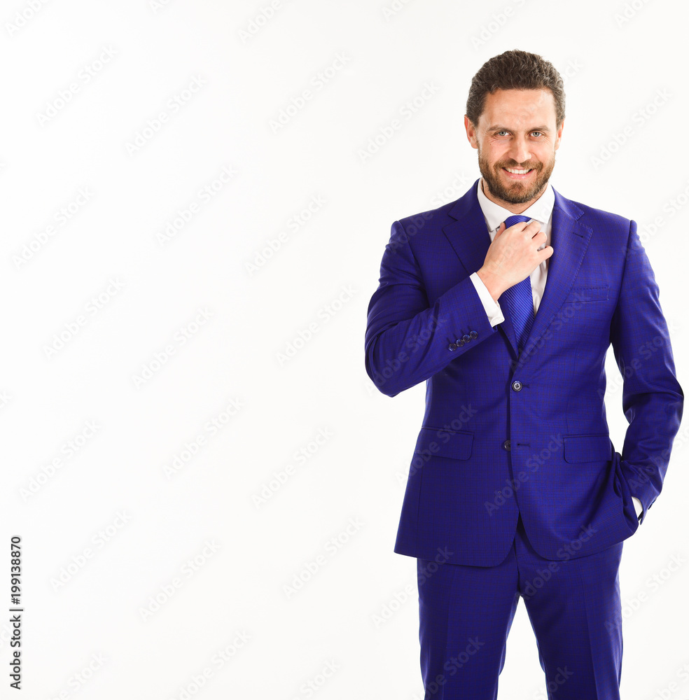Man with beard and smiling face touches his tie. Man with beard and smiling face touches his tie.