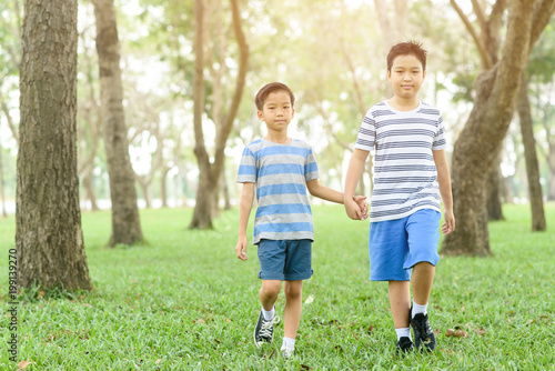 Two boy hold their hand and walk