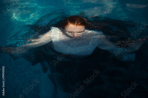 Beautiful model is posing in a swimming pool © Kateryna