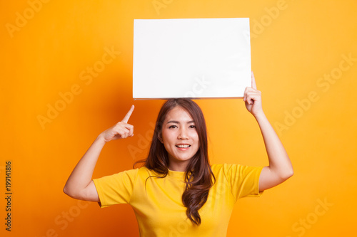 Young Asian woman point to blank sign.