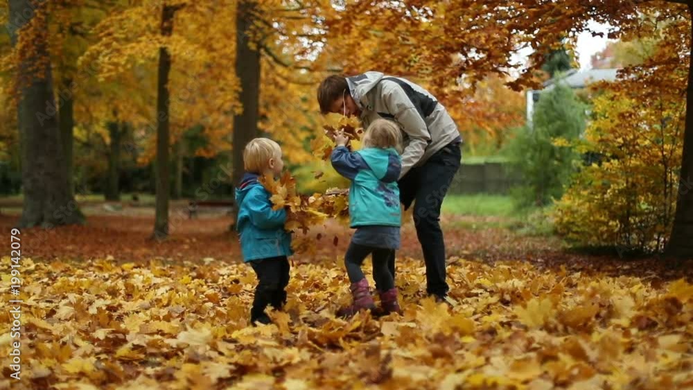 Teenager playing with little boy and girl in slow motion in park Teenager playing with little boy and girl in slow motion in park