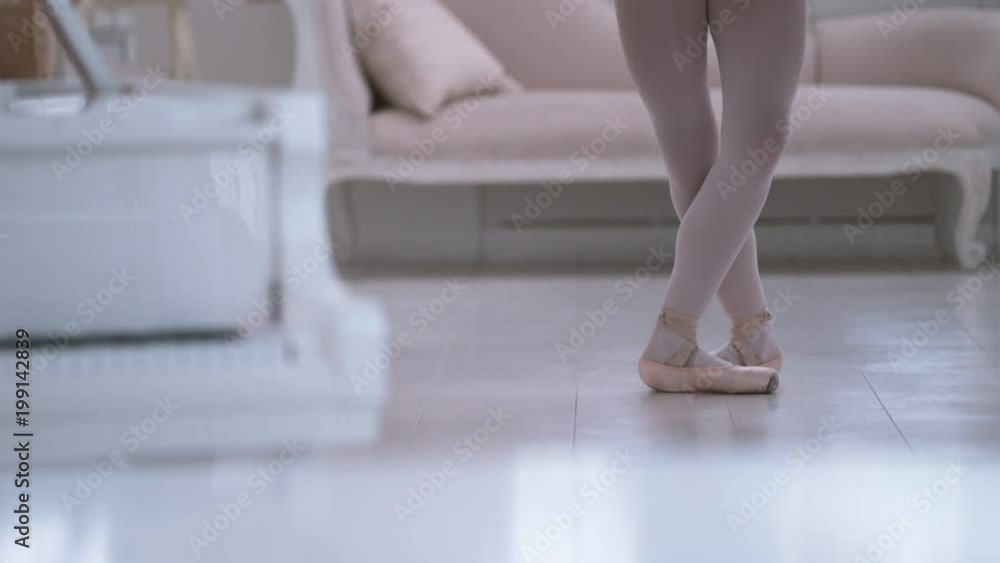 Graceful ballerina practicing ballet in white studio, slow motion Graceful ballerina practicing ballet in white studio, slow motion
