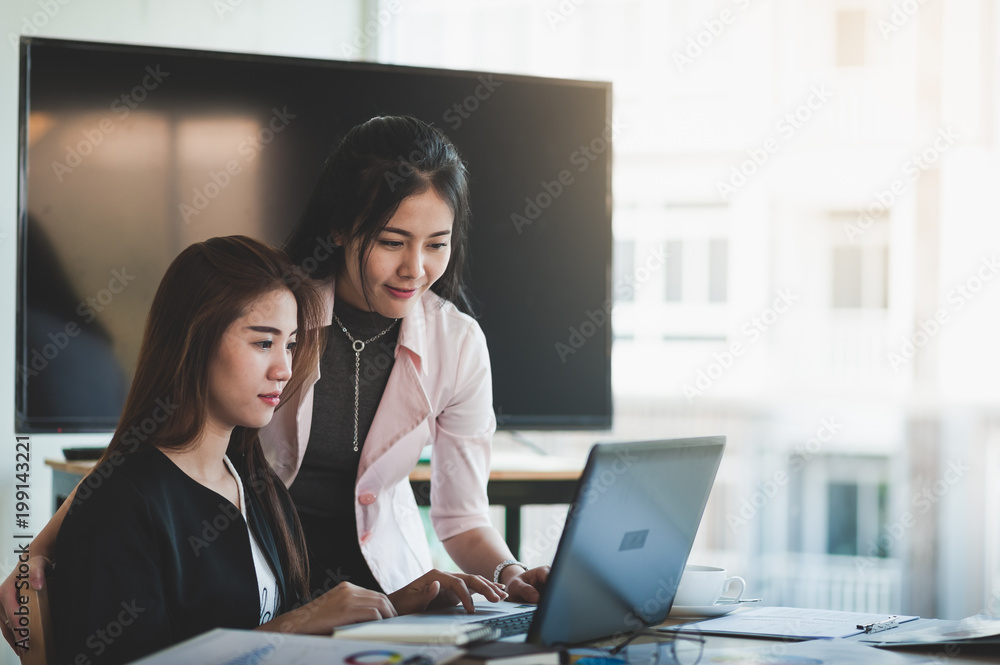 Young Asian women workers working together in office Young Asian women workers working together in office