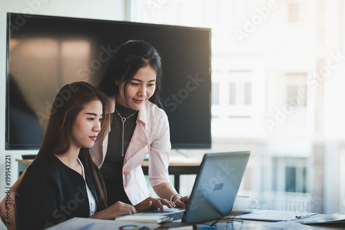 Young Asian women workers working together in office