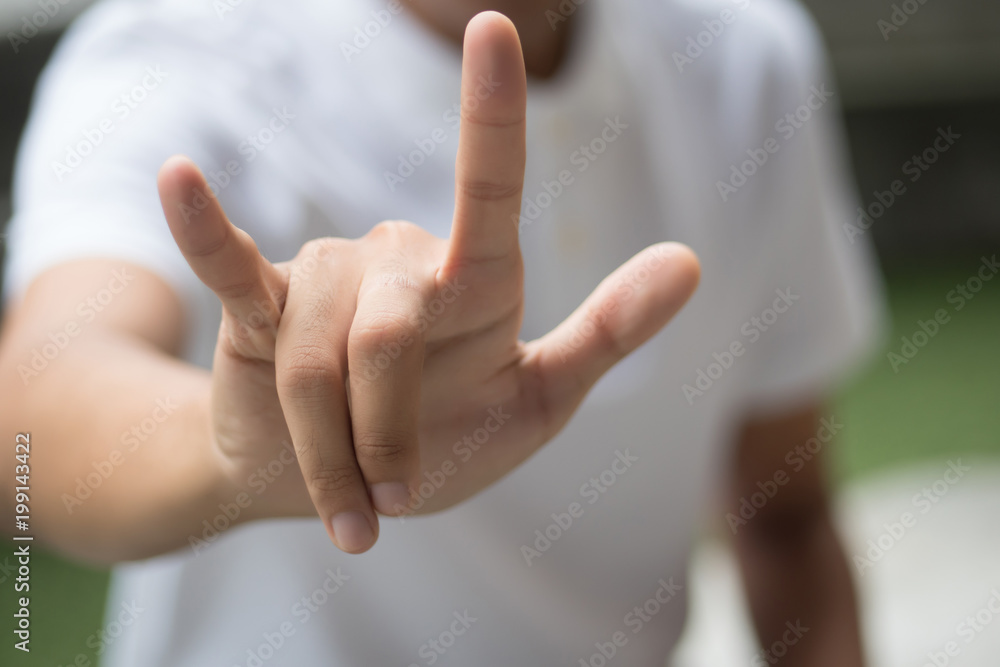 man with love or rock hand gesture; asian man showing love hand sign or ...