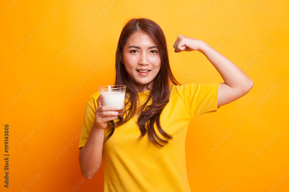 Healthy Asian woman drinking a glass of milk in yellow dress Healthy Asian woman drinking a glass of milk in yellow dress