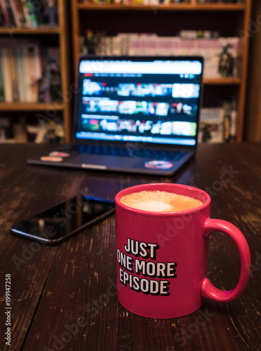 Fotografie Watching series with a cup of tea on wood table with cellphone