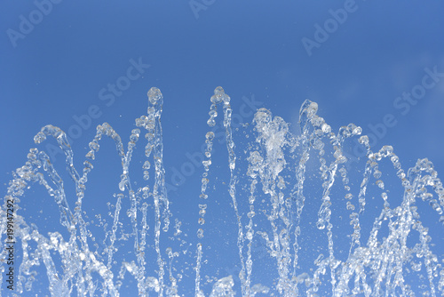 Beautiful fountain on blue sky background. Fountain with clear and cold water against the blue sky