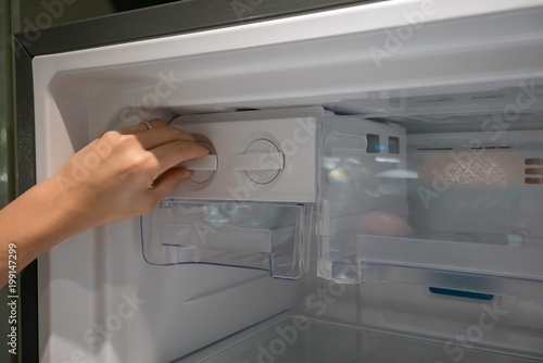 Fotografija Closed up woman hand twisting for ice from the ice maker