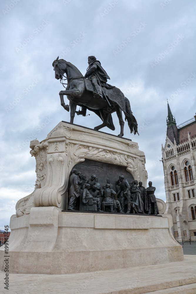 A statue of a rider in front of the Budapest parliament from the side