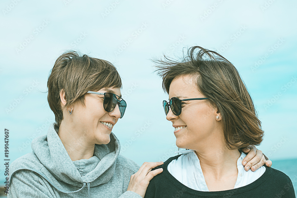 Two girls smiling and having fun on the beach. Healthy and cheerful lifestyle Two girls smiling and having fun on the beach. Healthy and cheerful lifestyle