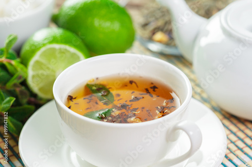 cup of black tea with mint leaves on a wooden table