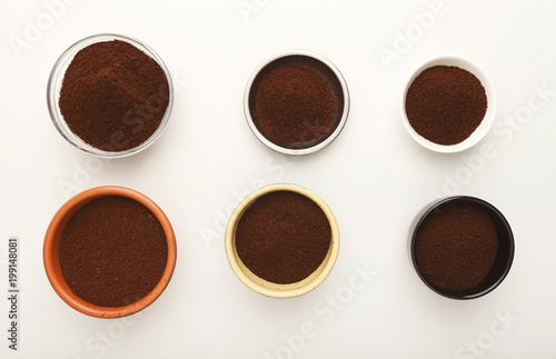 Roasted ground coffee in bowls, top view, white isolated background