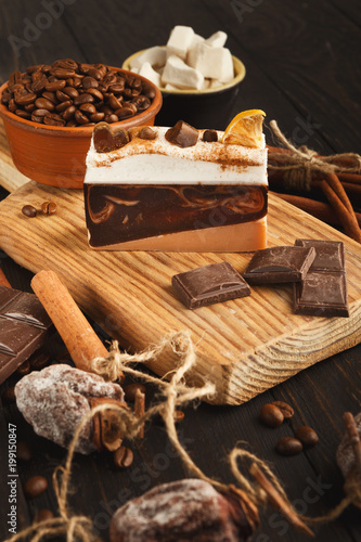 Various sweet treats  cakes and chocolate bars on dark rustic table  side view