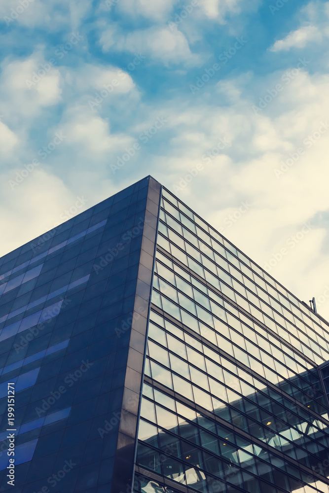 A beautiful, modern, mirrored building. The view from below. Sky with clouds. Corporate building. A beautiful, modern, mirrored building. The view from below. Sky with clouds. Corporate building.